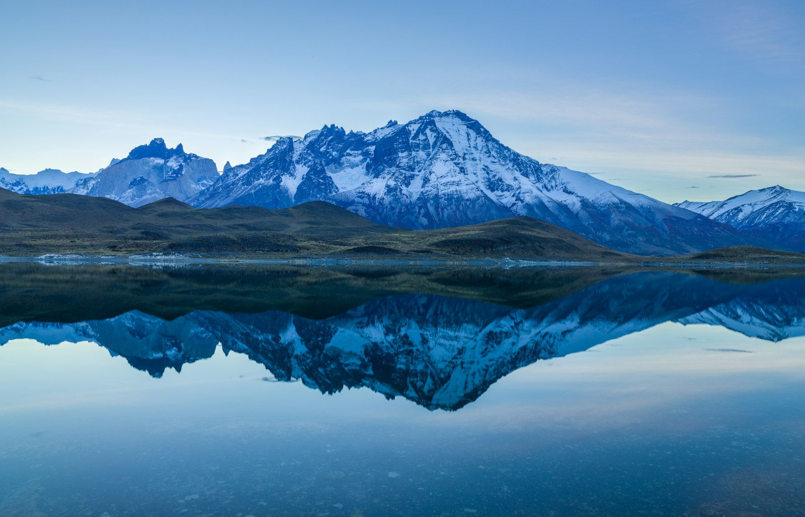Jagged granite peaks reflected in a still lake in Patagonia